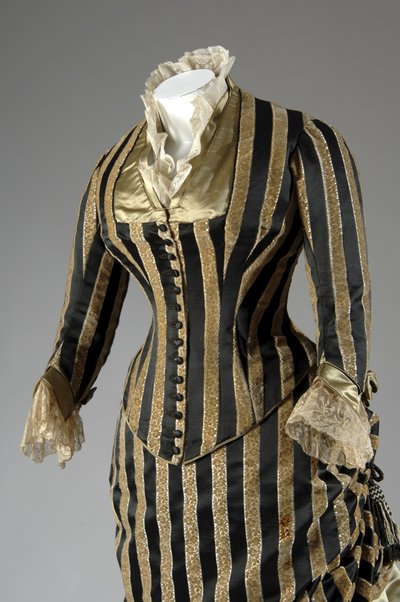 Robe de soirée, c.1884 (vue partielle oblique latérale). Satin de soie et velours coupé, dentelle, glands et franges en fil de soie. Charles Frederick Worth, France. - Charles Frederick Worth