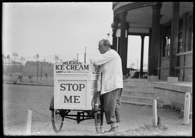 Un vendeur de crème glacée Eldorado à côté de son chariot tricycle devant un pavillon - Charles William Prickett
