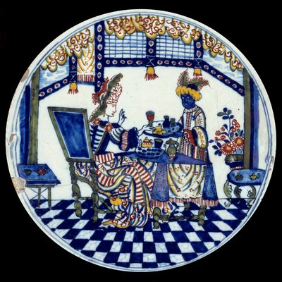 Assiette en porcelaine de Delft représentant une femme à une table servie par son serviteur noir. 1705 Sèvres, Musée National de la Céramique - Dutch School