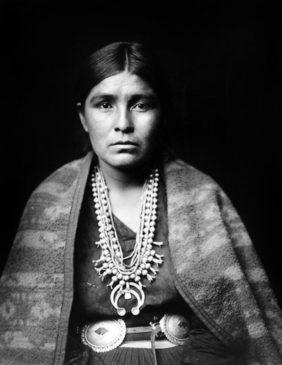 Femme Navajo portant un collier de fleurs de courge en argent, ceinture concho, couverture drapée sur les épaules, vers 1904, photo Edward S. Curtis - Edward Sheriff Curtis