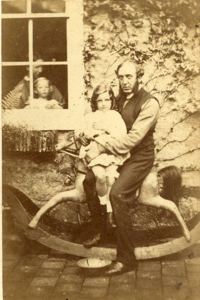 Père et fille assis sur un cheval à bascule avec frère et mère regardant par la fenêtre, années 1860 - English Photographer