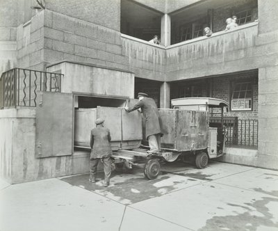 Ossulston Estate : éboueurs vidant un conteneur au bas de la goulotte à ordures - English Photographer