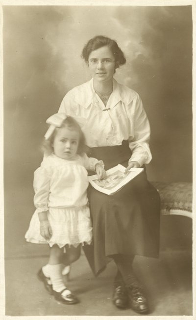 Jolie fille, mère ou gouvernante, montrant des photos à un jeune enfant - English Photographer