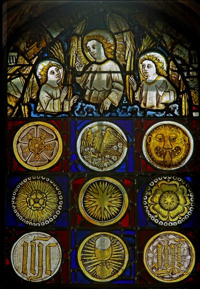Un panneau dans la fenêtre est représentant des anges au-dessus de 9 médaillons avec des éclats de soleil, des roses, une tête de léopard, un calice et des monogrammes - English School