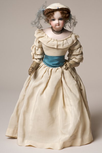 Poupée de mode en biscuit avec tête pivotante, portant une longue robe crème et un chapeau - English School