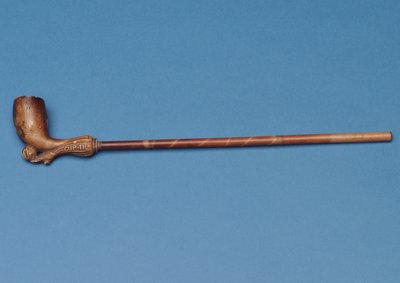 Pipe avec tige en bambou et botte sculptée frappant un ballon en dessous - English School