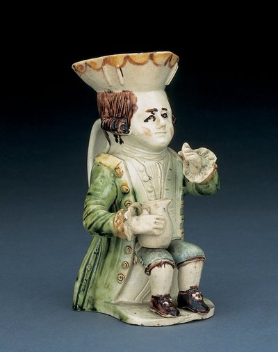 Cruche Toby buveur, son chapeau avec bord festonné brun et jaune, ses cheveux bruns incisés en queue et avec une rosette blanche assis avec une cruche balustre sur son genou, c.1770 - English School