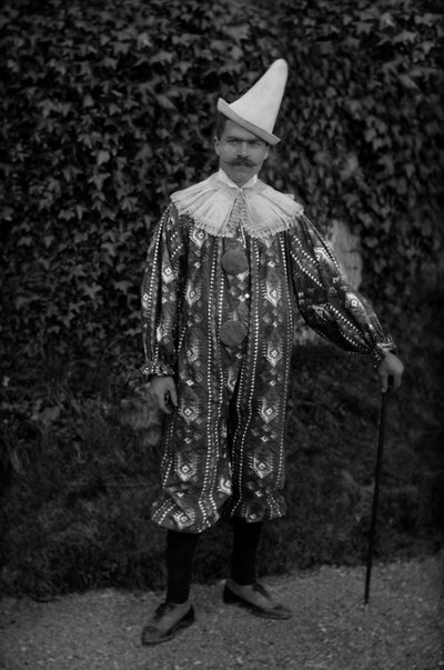 Un homme posant en costume de clown, à l