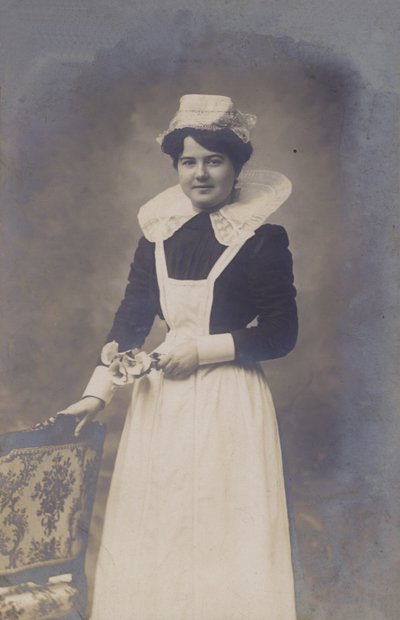 Jeune fille, domestique (?), tenant un petit bouquet de fleurs - French Photographer