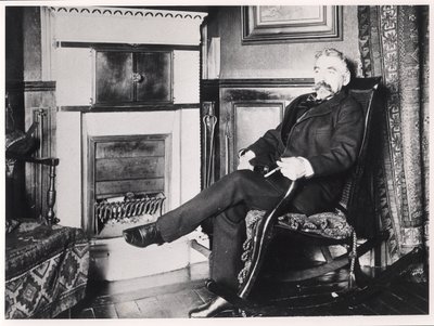 Stéphane Mallarmé (1842-98) assis près de la cheminée chez lui, rue de Rome, Paris - French School
