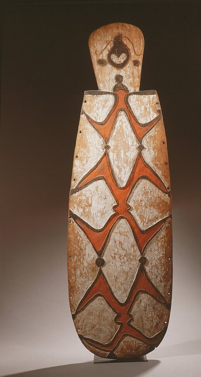 Bouclier ovale Asmat, sculpté en relief avec des figures stylisées, un masque en haut - Guinean New