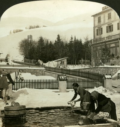 Femmes lavant des vêtements à la fontaine publique en plein hiver, Zuoz, Suisse - H. C. White