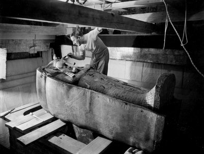Découverte de la tombe du pharaon Toutankhamon dans la Vallée des Rois (Égypte) : dans la chambre funéraire, Howard Carter travaillant sur le couvercle du deuxième cercueil, octobre 1925, photo par Harry Burton - Harry Burton