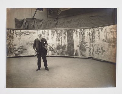 Claude Monet avec sa palette devant son œuvre 