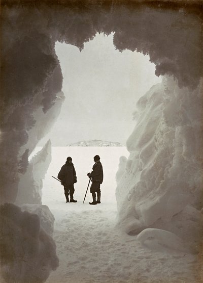 Hommes devant une grotte creusée dans la glace lors d