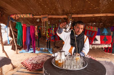 Un local servant du thé à la menthe à Erg Chebbi dans le désert près de Merzouga, Maroc, 2019 (photo) - Ira Block