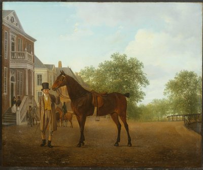 Un gentleman tenant un cheval sellé dans une rue près d