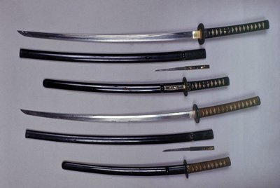 En haut : un katana, épée japonaise et son fourreau, wakizashi, épée courte japonaise dans son fourreau, petit poignard Kokatawa rangé dans le même fourreau. tous trois sont du 18e siècle. les inférieurs sont du 17e siècle - Japanese School