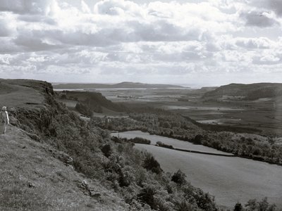 Une dame se tient sur une colline et regarde le paysage de Scout Scar. - Joseph Hardman