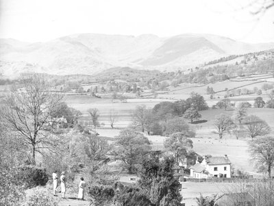 Trois femmes debout regardant un lac à Esthwaite, avec les montagnes en arrière-plan. - Joseph Hardman