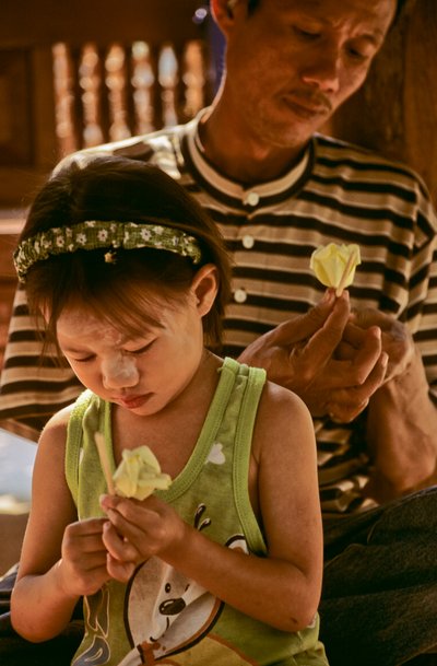 Père séropositif et fille fabriquant des fleurs en papier, 2002 - Karen Kasmauski