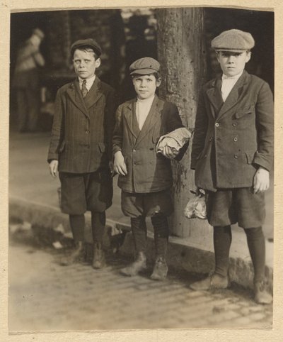 [Trois garçons dans la rue de la ville en culottes et bonnets] - Lewis W. Hine