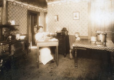 Femme insérant des poils dans des brosses à dents dans sa cuisine, c.1912 - Lewis Wickes Hine