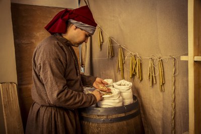 Reconstitution historique : Bougies et sacs de blé, seigle et orge dans l