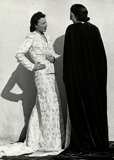 Deux mannequins présentent des créations de la maison de couture italienne "Dragoni". Un mannequin porte une tenue en tissu damassé composée d