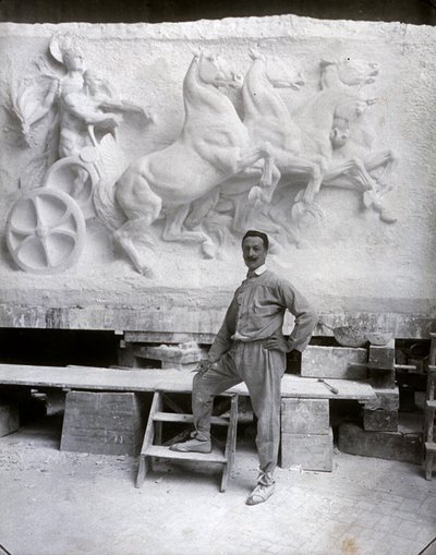 Portrait en pied du célèbre sculpteur Pietro Canonica. Il pose dans son atelier devant un haut-relief en marbre sur lequel il travaille - Mario Nunes Vais