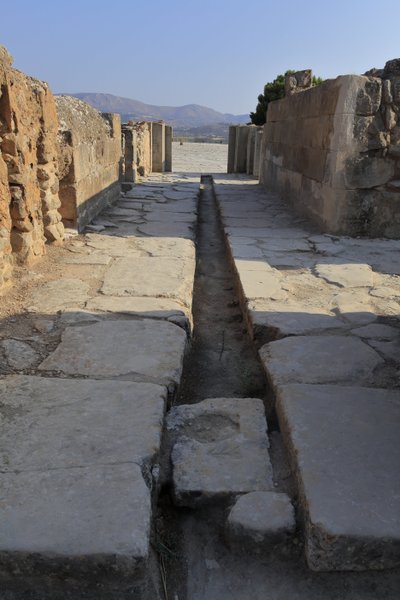 Site archéologique minoen de Phaistos. Large corridor avec un conduit de drainage derrière la porte de l