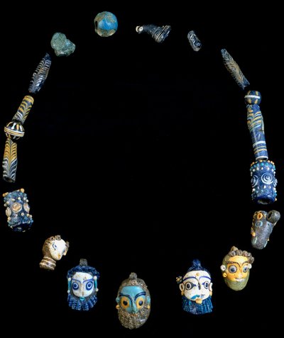 Collier en pâte de verre avec pendentifs représentant des têtes barbus, originaire d