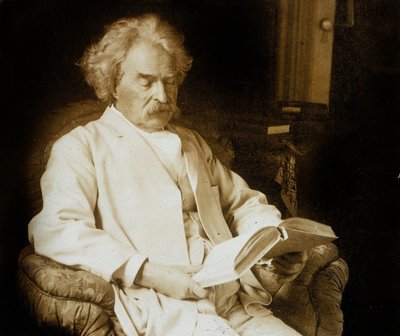 Mark Twain (Samuel Langhorne Clemens 1835-1910) écrivain américain, ici en train de lire, c. 1910 - Photographer American