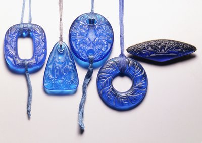 Quatre pendentifs en verre turquoise et une broche en verre monté en métal doré - Rene Jules Lalique