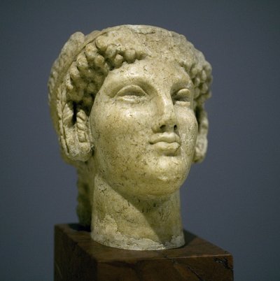 Tête de jeune fille (Korè), sculpture de la période hellénistique romaine (3e-2e siècle après notre ère), visage très expressif, pommettes saillantes vers l