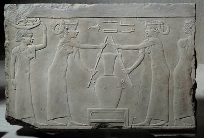 Antiquité égyptienne : bas-relief en calcaire représentant des femmes pressant des fleurs de lys pour extraire l