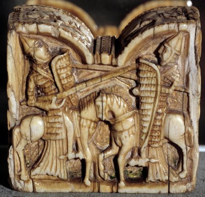 Art roman : pion de jeu représentant une bataille entre deux chevaliers. Sculpture en ivoire. D