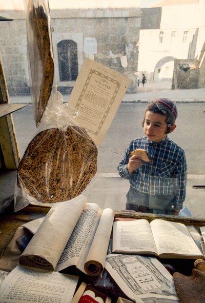 Garçon juif conservateur mangeant un gâteau regarde dans une librairie religieuse - Ted Spiegel