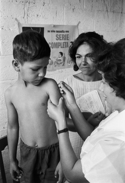 Une infirmière inocule un garçon équatorien avec un vaccin lors d
