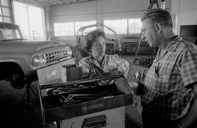 Chauffeur de camion Mildred Cooper discutant avec un mécanicien dans un garage - Ted Spiegel