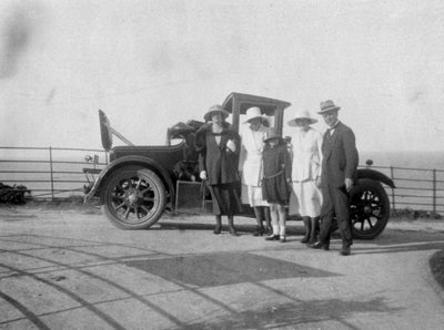 Un groupe de personnes devant leur voiture au bord de la mer, vers 1920 - Unbekannt