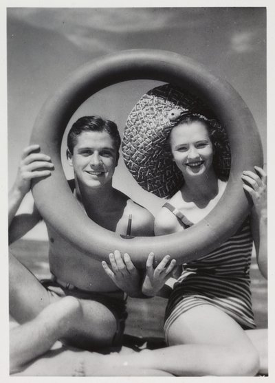 Homme et femme regardant à travers une bouée sur la plage, vers 1935 - Unbekannt