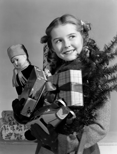 Jeune fille portant une brassée de cadeaux de Noël, vers 1950 - Unbekannt
