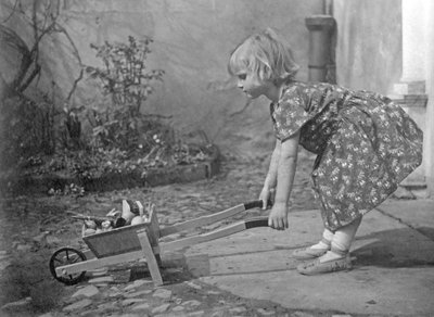 Petite fille jouant avec une brouette. Photographie vers 1931 - Unbekannt