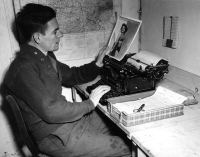 Seconde Guerre mondiale (1939-1945) : Mutzig (Alsace) France 1 décembre 1944 : Le caporal Flanerty chroniqueur du Beachead News (journal des GI) regarde une photographie de pin-up qu