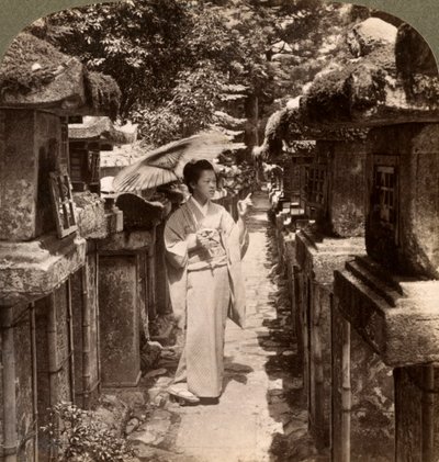 Une femme dévote shinto comptant les lanternes en pierre, sanctuaire Kasuga, Nara, Japon, 1904 - Underwood and Underwood