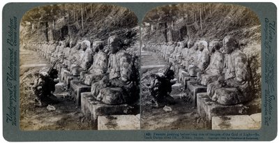 Paysanne priant devant une rangée de statues du Dieu de la Lumière, rivière Daiya, Nikko, Japon, 1904 - Underwood and Underwood