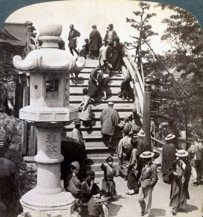 Adorateurs traversant le pont semi-circulaire vers le temple de Kameido au-delà, regardant vers le nord, Tokyo, Japon - Underwood and Underwood