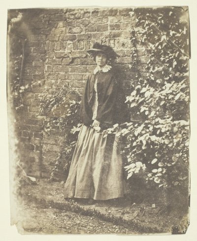 Mme Craik appuyée contre un mur et des buissons - Unknown