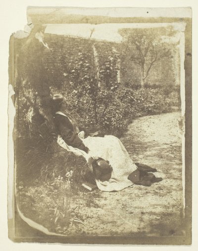 Mme Craik allongée dans le jardin avec un chapeau et un livre - Unknown